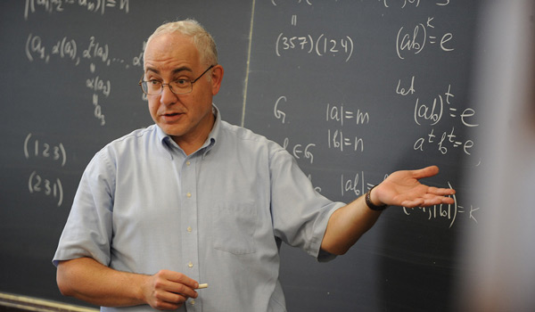 A math professor at Catholic ϲapp teaching a class.