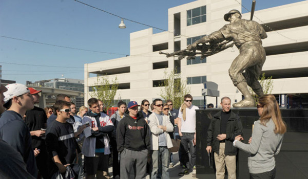 A Catholic ϲapp class standing next to a baseball statue on a class outing.