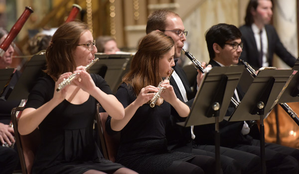 Catholic ϲapp woodwind instrument players performing on stage.